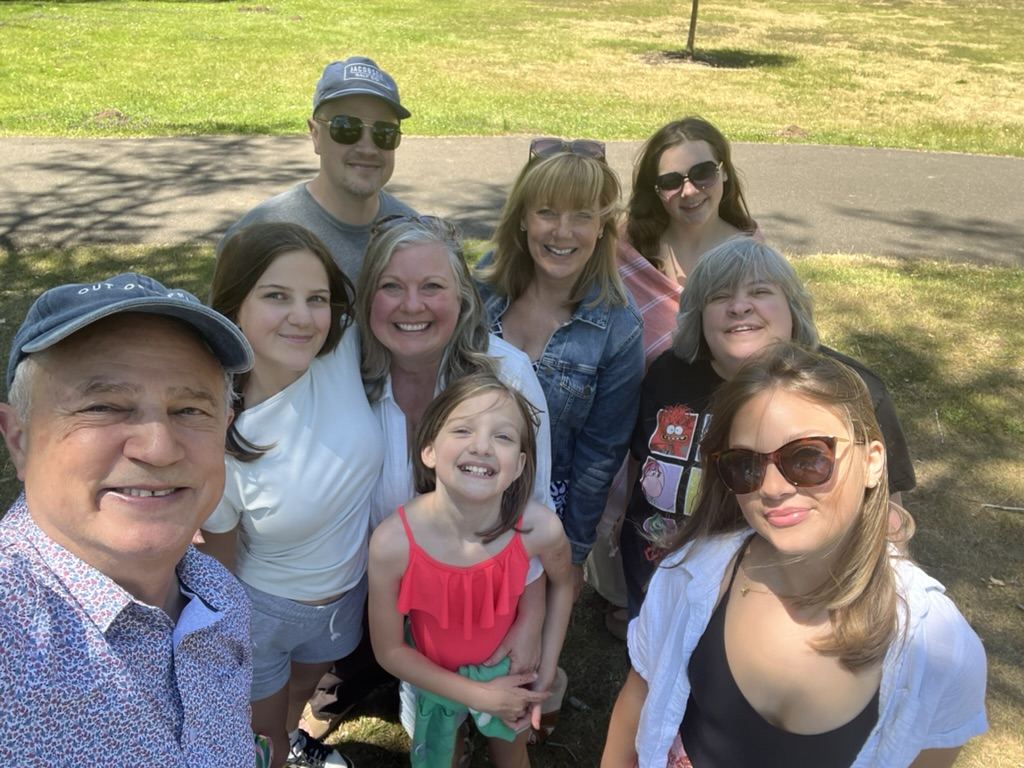 Group selfie in a park: Mark Boyd in a cap at front left with Lisa Marie and family