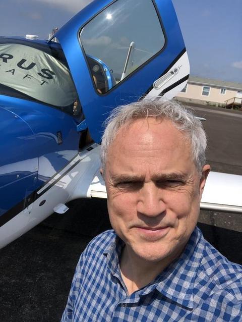 Mark Boyd taking a selfie on the ramp in front of the Cirrus with its door open