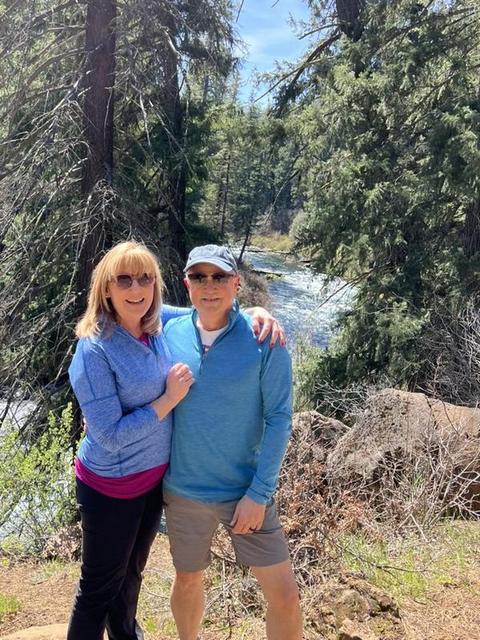Mark and Lisa Marie Boyd standing beside a river in a pine forest