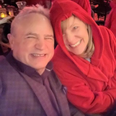 Night-time selfie of Mark and Lisa Marie Boyd, Lisa Marie in a red hooded robe, at a New York rooftop bar