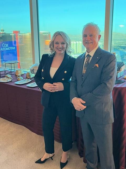 Mark Boyd in a gray pinstripe suit with his daughter, Dr. Crystal Alstot, at a high-rise event overlooking the Las Vegas Strip